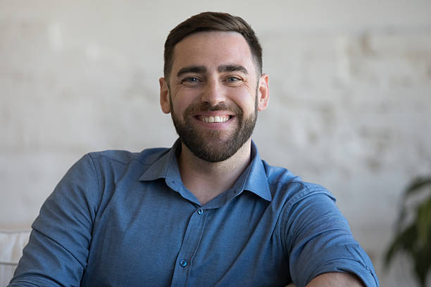 istock Cheerful confident handsome adult man sitting on couch 2205921644