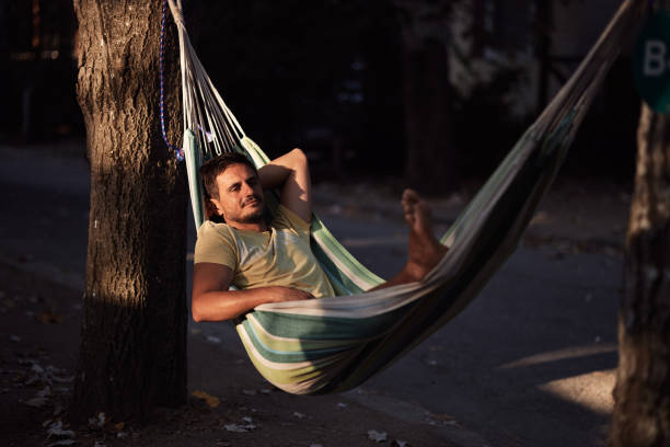 Man enjoying hammock by the tent in nature. Summer vacation.
