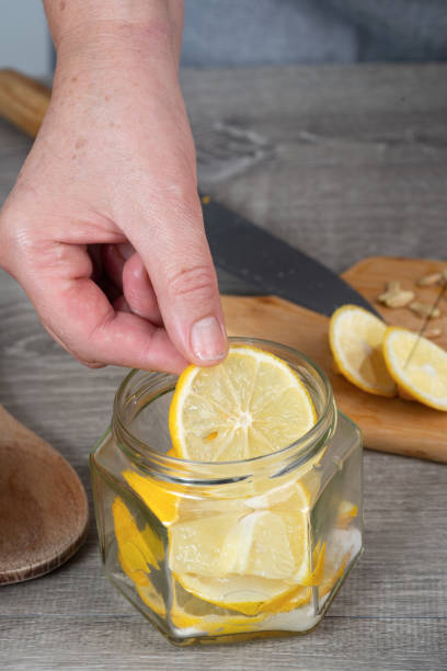 istock woman's hands canning lemon. pour sugar into  jar of lemon. 2205923728