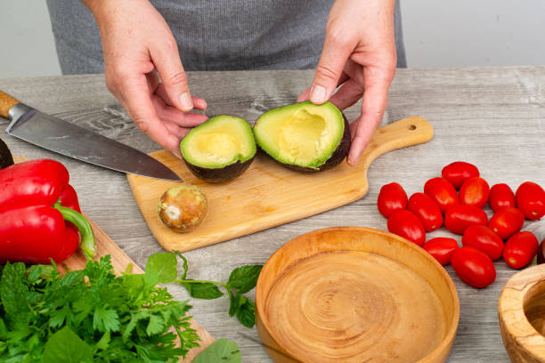 istock cook preparing avocado for serving. various vegetables and spices on the kitchen table.Close up. 2205923797