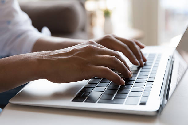 istock Female hands working on laptop keyboard, close up cropped shot 2205923991