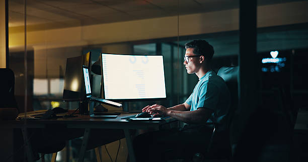 istock Business, man and computer screen with laptop at night for trading algorithms, finance planning or chart analysis. Employee, person or stats graph for investment revenue and financial report deadline 2205925543