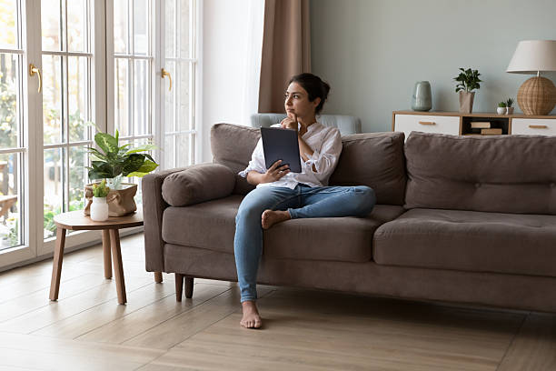 istock Pensive Indian woman consider on-line purchase using digital tablet 2205926657