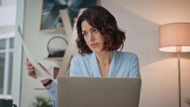 istock Overloaded worker reviewing papers sitting corporate workplace office closeup. 2205927289