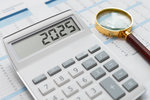 istock Calculator Displaying ‘2025’ with Magnifying Glass on Financial Documents 2205927746