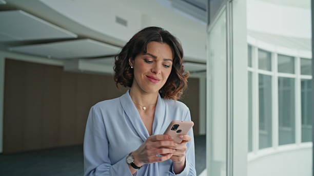 istock Positive office worker texting smartphone walking corporate hallway closeup. 2205928049
