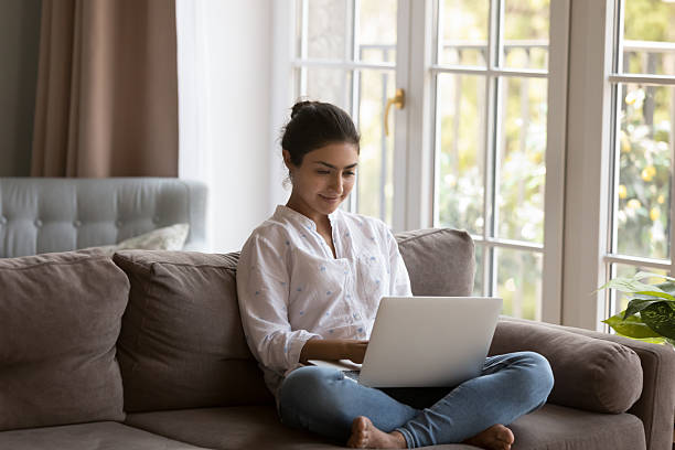 istock Cute Indian woman spend leisure at home using laptop 2205928050
