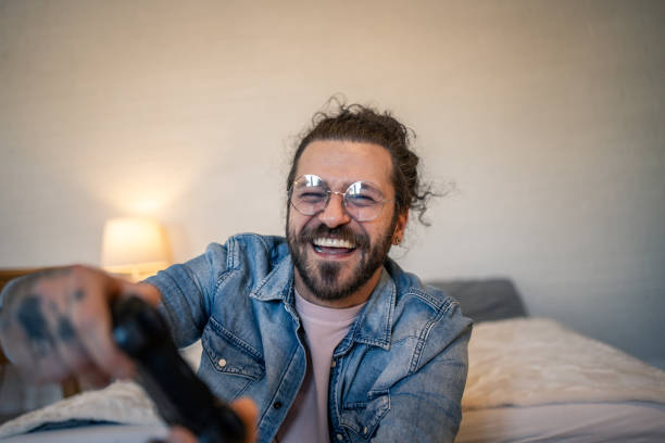 istock Young man having fun playing video games in his bedroom 2205929042