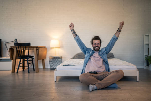 istock Happy gamer celebrating victory in his bedroom 2205929068