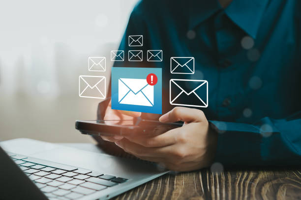 istock Person using smartphone to manage email notifications with laptop in modern workspace, Business concept 2205937865