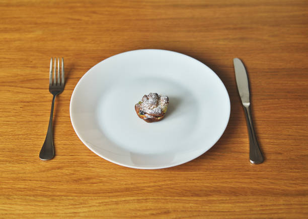 A festive Easter cake (Paska) rests on a plate, accompanied by a fork and knife placed beside it. The scene suggests a ready-to-eat dessert or a beautifully presented element of an Easter celebration.