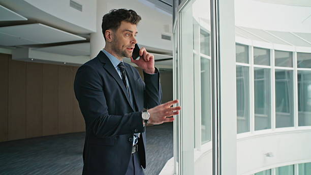 istock Businessman complaining work cellphone conversation in hallway window closeup. 2205938490