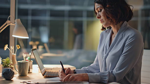 istock Hardworking employee writing documents sitting evening office closeup. Late work 2205939428