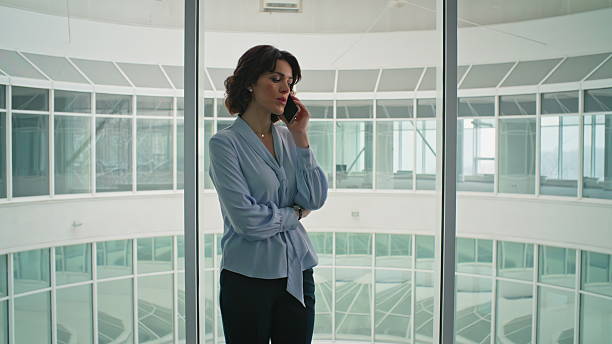 istock Pensive entrepreneur having call at office corridor window closeup. Serious lady 2205940740