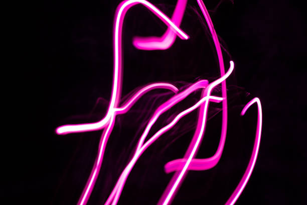 istock Pink light trails creating abstract shapes on a black background 2205940752
