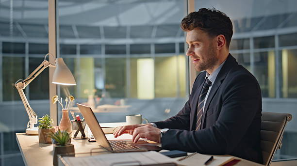 istock Smiling manager finish work on laptop at evening office closeup. Satisfied man 2205941410