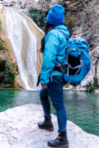 istock Female hiker admiring stunning waterfall in natural setting 2205941780