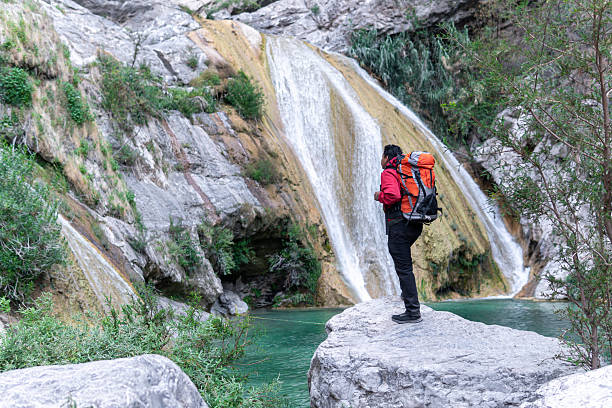 istock Hiker contemplating stunning waterfall in natural setting 2205942025