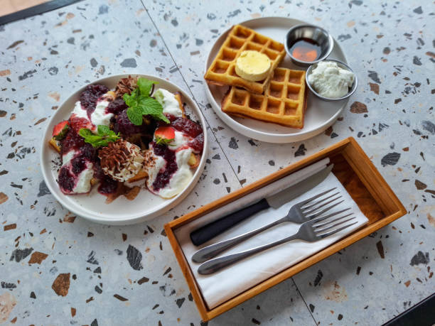 Berry Paradise Waffle With Strawberry Compote, Strawberry Fruit, Cheese Cream, Biscuit, Chocolate Powder And Fresh Mint Leaves. The Classic Waffle With Butter, Cheese Cream And Maple Syrup. Dessert Food Menu.