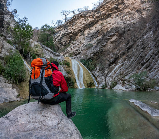 istock Hiker resting near waterfall in the mountains 2205942380