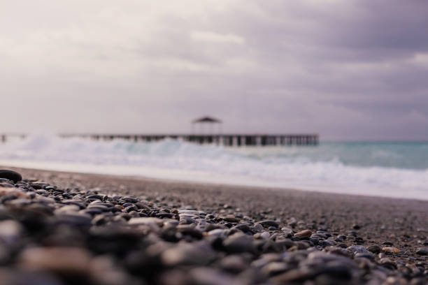 A view of a rocky beach in Turkey, showcasing the rough, stony surface typical of some coastal areas. Wearing water shoes is recommended for comfort and safety.