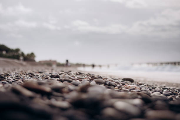 A view of a rocky beach in Turkey, showcasing the rough, stony surface typical of some coastal areas. Wearing water shoes is recommended for comfort and safety.