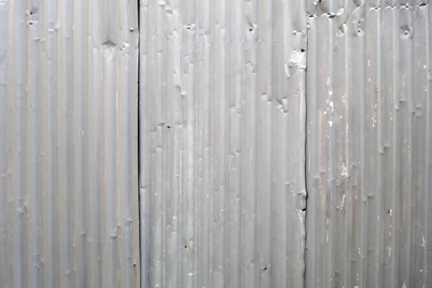 Dirty corrugated metal crumpled fence as industrial background