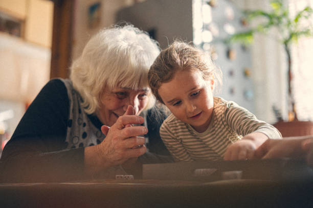 We always cook together. Granddaughter and grandmother preparing food. Focus is on foreground.