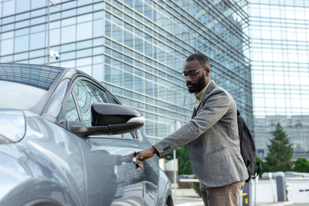 istock Handsome man entering the car in the city 2205946509