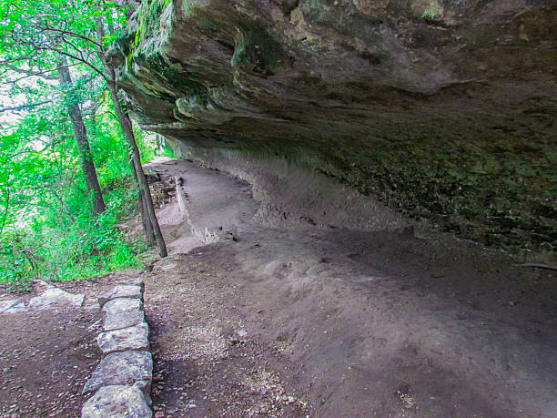 istock Underground Cave Stone Edge With Trees Surrounding It 2205947887