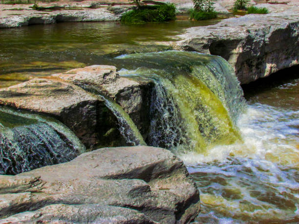istock Waterfall Into With Large Gray Rock Into A Stream 2205947965