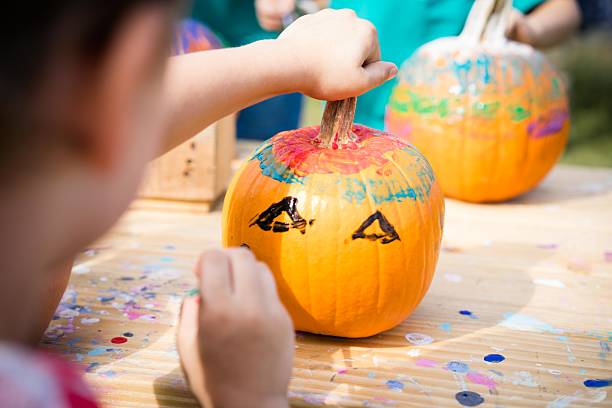 Boy Painting a Pumpkin