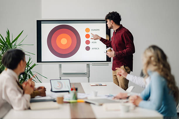istock Young businessman explaining market analysis to colleagues during a presentation in a modern office 2205951834