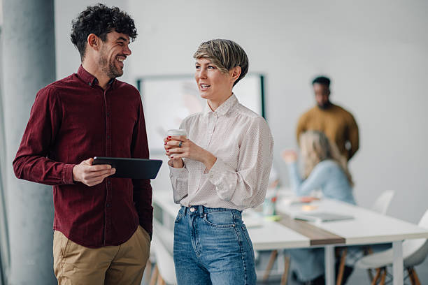 istock Smiling business colleagues discussing work in modern office 2205951935