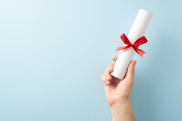 istock A hand presenting a rolled diploma tied with a red ribbon, symbolizing achievement and education 2205956953