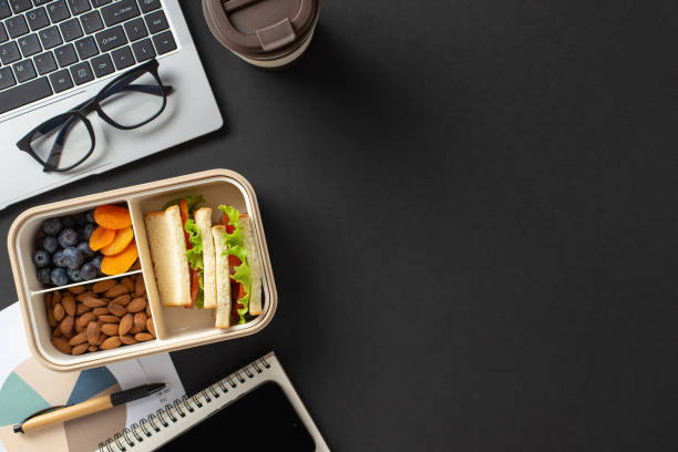 istock Organized workspace featuring a laptop, glasses, and a healthy lunch with fresh snacks 2205956964