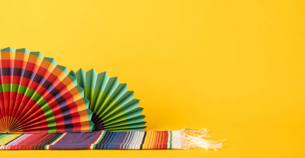 istock Festive decorative elements including paper fans and fabric patterns on a bright yellow backdrop 2205956987