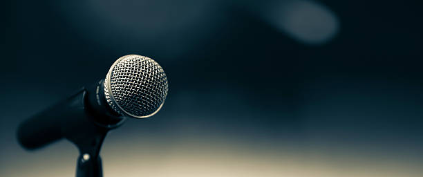 istock Public speaking backgrounds, Close-up the microphone on stand for speaker speech presentation stage performance with blur and bokeh light background. 2205958886