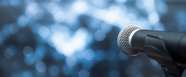 istock Microphone Public speaking backgrounds, Close-up the microphone on stand for speaker speech presentation stage performance with blur and bokeh light background. 2205958907