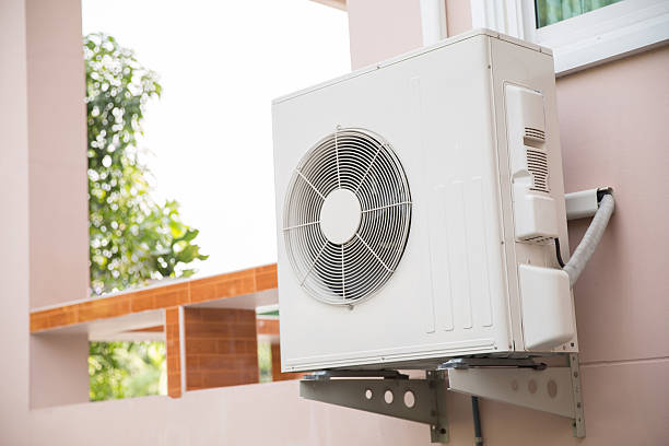 istock External split wall type of house air conditioner compressor unit installed on the outside of the building. 2205959139