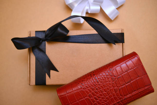 istock A red crocodile leather ladies purse on a wrapped gift box 2205960981