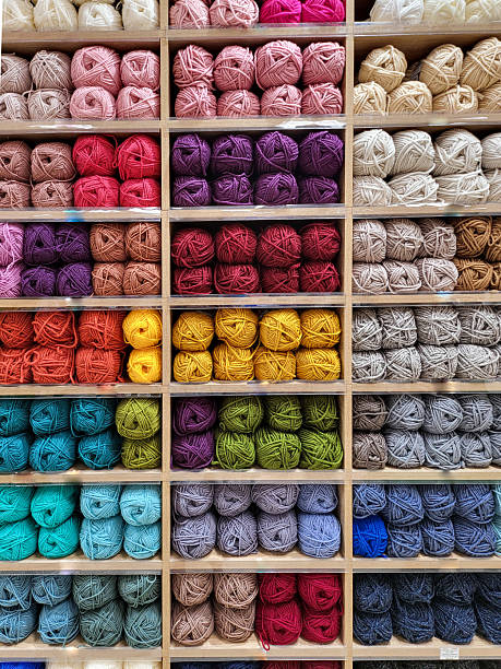 istock Shop shelf with multicolored different sorts yarn for knitting. Various color for creativity, crocheting and needlework. Bright colorful yarn balls full frame vertical background 2205962661