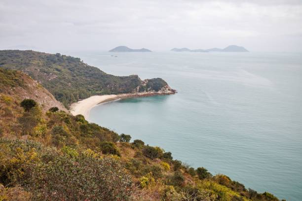 istock Serene Coastal Landscape with a Curved Beach in a Cloudy Day 2205965132