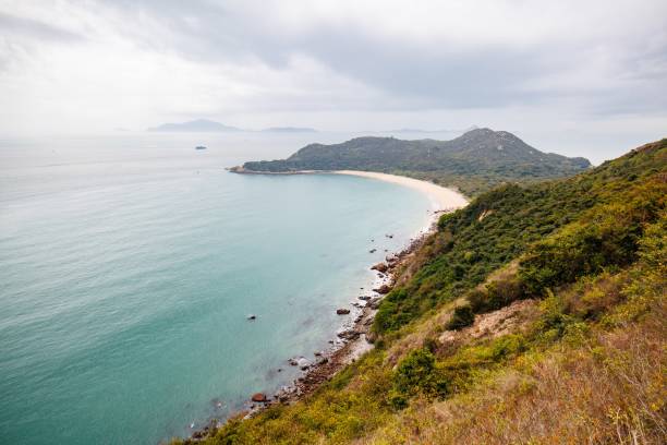 istock Serene Coastal Landscape with a Curved Beach in a Cloudy Day 2205965212