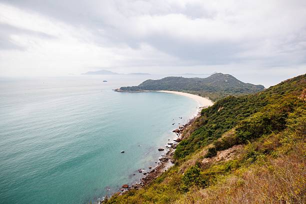 istock Serene Coastal Landscape with a Curved Beach in a Cloudy Day 2205965215
