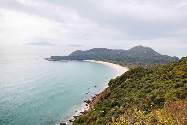 istock Serene Coastal Landscape with a Curved Beach in a Cloudy Day 2205965256