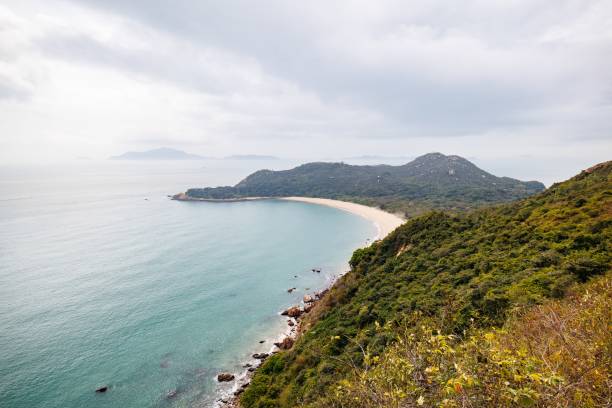 istock Serene Coastal Landscape with a Curved Beach in a Cloudy Day 2205965316