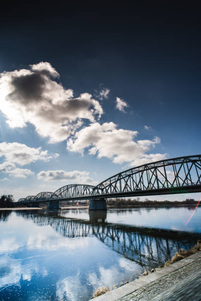 istock Beneath the blue sky, a bridge reflects over calm waters in a tranquil riverside setting 2205967250
