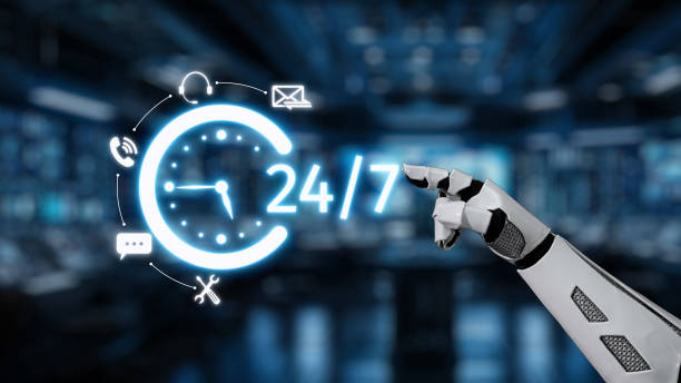 istock Futuristic robotic hand pointing at a glowing 24-hour clock symbol with communication icons in a technology-driven workspace setting. Auvana 2205967369