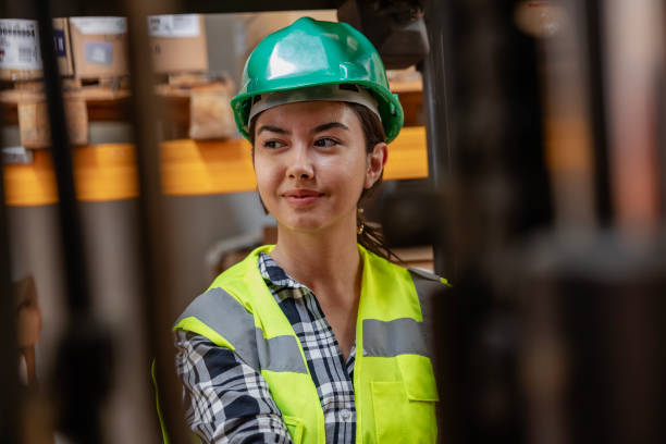 istock Efficient Warehouse Operations: Female Forklift Driver Poses and Drives Worklift at Distribution Warehouse. 2205973578